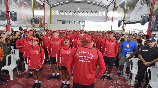 A Prefeitura de Maricá, por meio da Secretaria de Proteção e Defesa Civil, realizou nesta sexta-feira (25/11), na quadra da Escola de Samba União de Maricá, em Itapeba, a formatura de 61 agentes. Os novos servidores atuarão como guarda-vidas em toda a orla maricaense, que tem 46 km de extensão. O prefeito Fabiano Horta fez questão de parabenizar os formandos, enfatizando que a Defesa Civil de Maricá desempenha um papel fundamental na prevenção e na proteção da cidade. “Vocês lidarão com uma série de situações, como o desespero e a dor de seres humanos que certamente terão a vida preservada pela ação de vocês. Por isso, quero saudar a cada por colocarem suas vidas à disposição do cidadão maricaense” explicou o prefeito. O secretário de Proteção e Defesa Civil, Fabrício Bittencourt agradeceu ao corpo de instrutores que contribuiu para a formação dos profissionais. “Hoje é um dos dias mais felizes da minha vida pública, por poder estar aqui, formando esses servidores após muita resistência e mudança de paradigmas. Mas eu creio que o resultado valeu a pena. Um dia memorável, de festa, realização e conquista. Parabéns aos alunos Salvamar Maricá”, destacou o secretário. Curso de formação Os novos agentes passaram por curso de formação que teve duração de quatro meses e incluiu uma série de disciplinas, entre elas o estatuto do servidor público, regulamentação da legislação do plano de cargos e salários, normas técnicas de vistoria, noções básicas de hidrologia, engenharia, geologia, corrida, natação, salvamento e prevenção em afogamento, entre outras. O instrutor do curso, major Wellington Silva, falou sobre a importância da chegada de novos membros à equipe. “Esses profissionais são essenciais para a proteção dos 46 km de nossa orla e serão pessoas que, com certeza, vão fazer a diferença na vida da nossa população, já que ela poderá se sentir mais segura com a presença dos agentes. Vocês serão os melhores profissionais tanto no serviço de guarda-vidas, quanto nas ocorrências relacionadas às chuvas”, frisou Wellington. O primeiro colocado do concurso, Derick Oliveira, foi o orador da turma de 2022. “Qualquer coisa que eu fale não será suficiente para descrever a trajetória de luta e aprendizado que tivemos nesses meses de curso. Todos os ensinamentos de excelência foram de suma importância na construção desses novos agentes, que continuarão em constante aprendizado daqui pra frente”, disse Oliveira, que estava muito emocionado. Praias receberão o reforço de profissionais capacitados A espera valeu a pena. Foi o que afirmaram os novos integrantes do Salvamar de Maricá, Daniel Coelho e Sara Egger. Daniel, 39 anos, era um dos mais emocionados. "Foi muito difícil estar aqui, muita luta. Passar pelo curso de formação foi muito difícil. Tudo foi feito com muito suor e muita raça. Só tenho felicidade e gratidão a Deus”, contou em lágrimas, ao lado da esposa grávida. "É muito gratificante passar por esse momento e compartilhar com meus amigos, porque nós somos uma família, não mais apenas colegas de trabalho. Estou muito feliz, agora, que vamos começar a trabalhar e servir à população", comemorou Sara Egger, 32 anos, moradora de Niterói. Segue link com fotos:https://www.flickr.com/photos/prefeiturademarica/albums/72177720303974467/with/52523263335/ Crédito: Clarildo Menezes