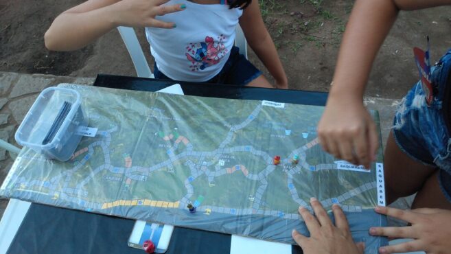 Vermelhinhas, Turistando, TWI, Faby Ferraz, jogos educativos, gamificação, Maricá, ciclovias, inclusão, acessibilidade, educação lúdica, cultura local, game design, jogo de tabuleiro, trânsito consciente