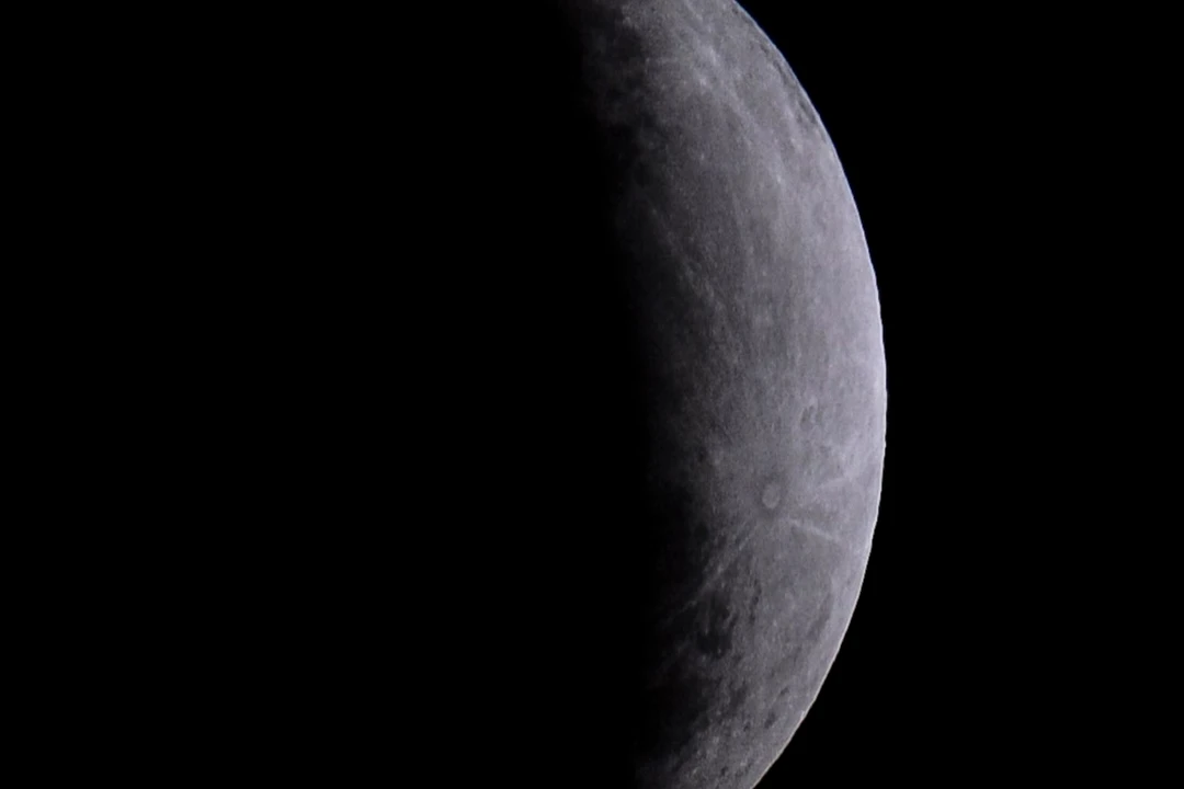 Lua cheia no céu noturno com a sombra da Terra cobrindo parcialmente a sua superfície durante o eclipse.
