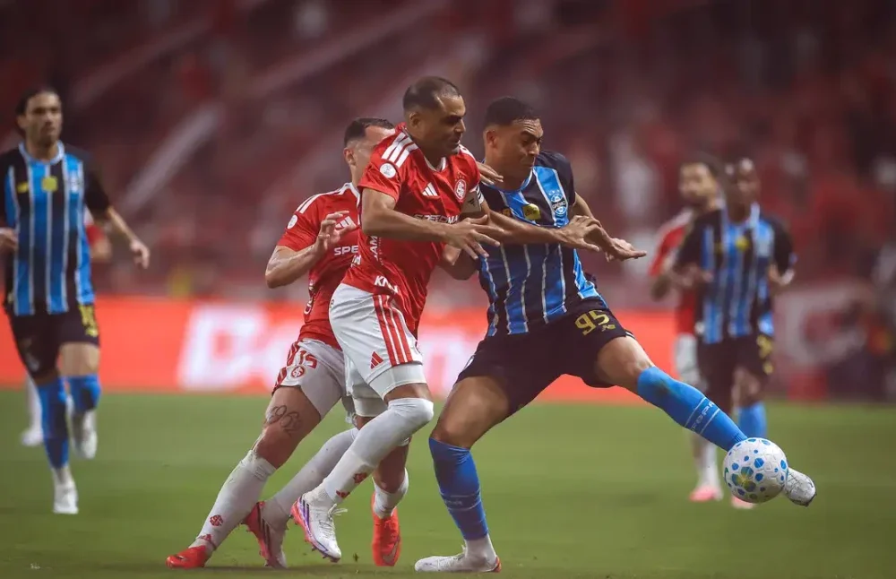 Jogadores de Internacional e Grêmio em disputa de bola durante clássico Grenal válido pela Copa do Brasil no estádio Beira-Rio.