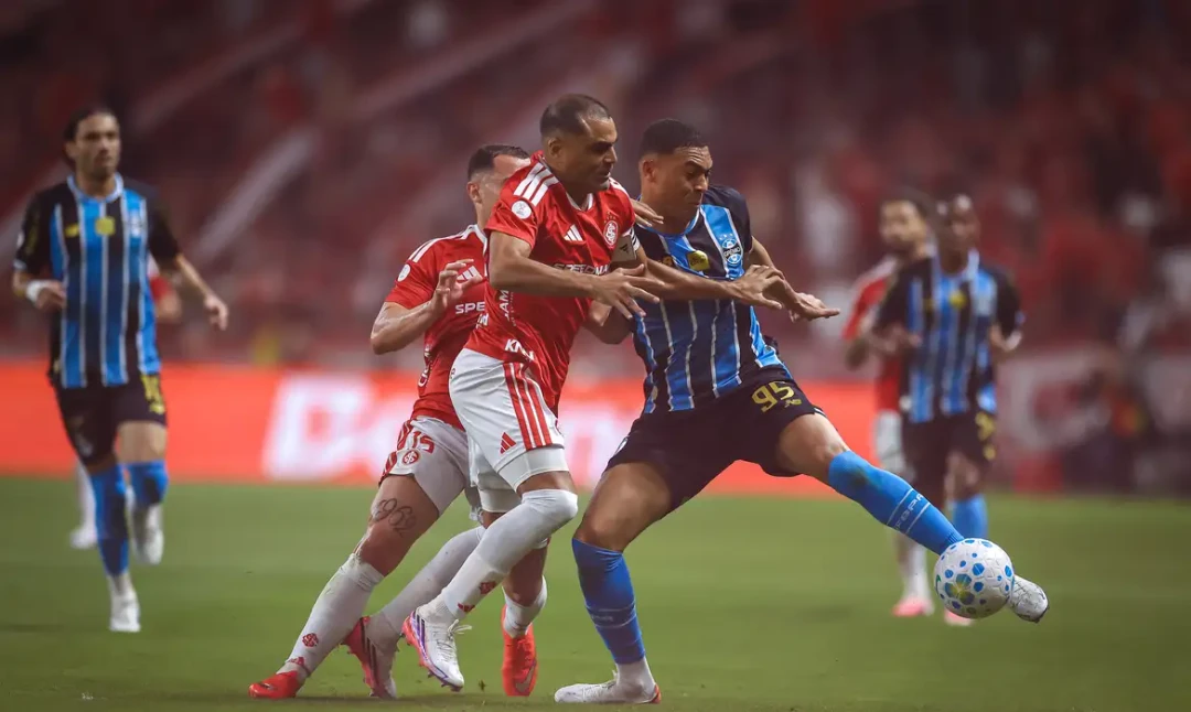 Jogadores de Internacional e Grêmio em disputa de bola durante clássico Grenal válido pela Copa do Brasil no estádio Beira-Rio.