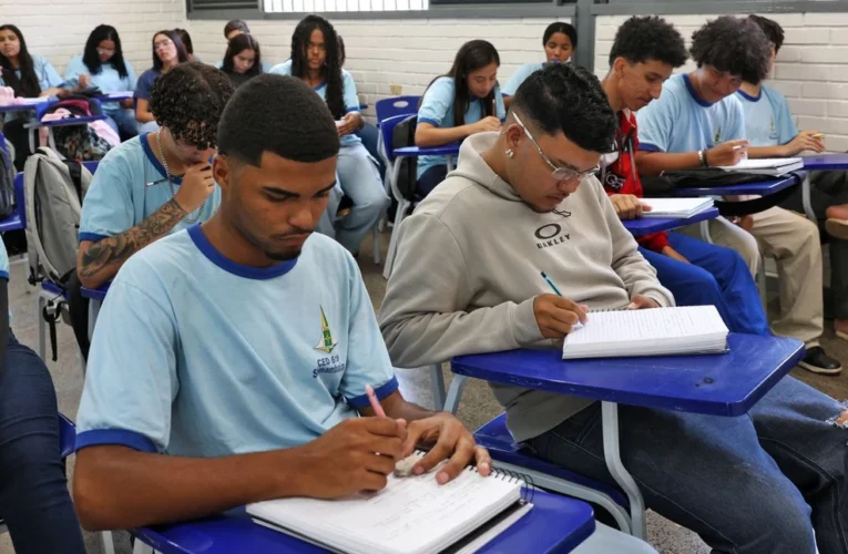 Estudante de ensino médio utilizando um celular para acessar a plataforma do programa Pé-de-Meia