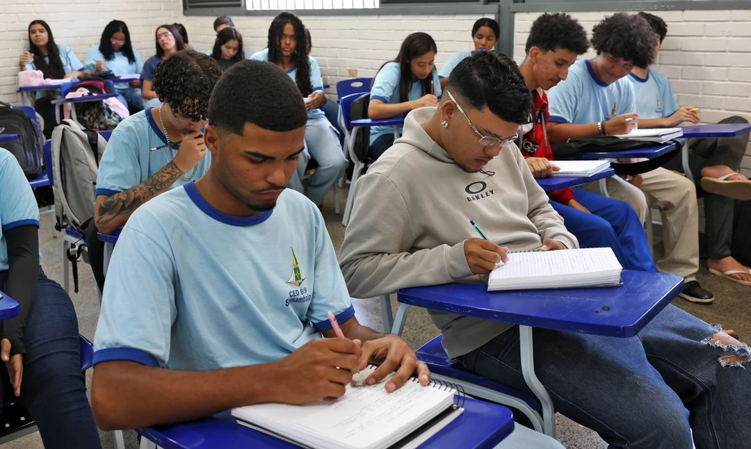 Estudante de ensino médio utilizando um celular para acessar a plataforma do programa Pé-de-Meia