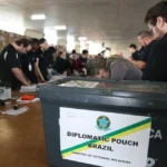 Victoria Duarte, estudante brasileira no Canadá, segurando o título de eleitor para as eleições presidenciais de 2026
