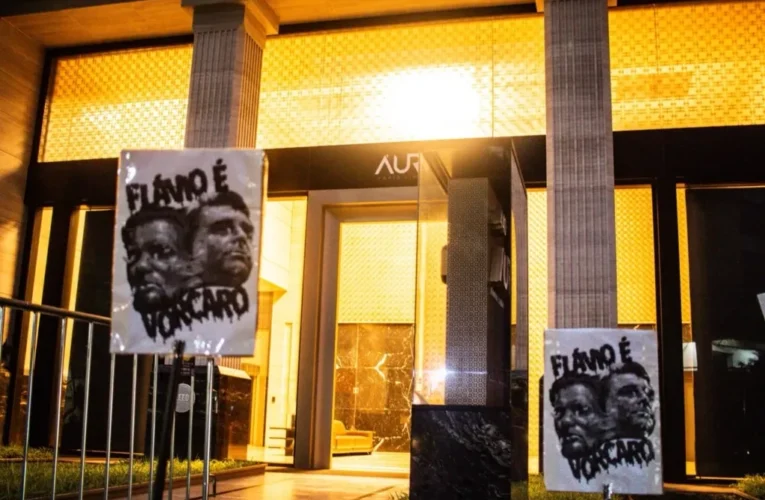 Jovens protestam contra suposta aliança entre Flávio Bolsonaro e ex‑banqueiro Vorcaro no antigo prédio do Banco Master