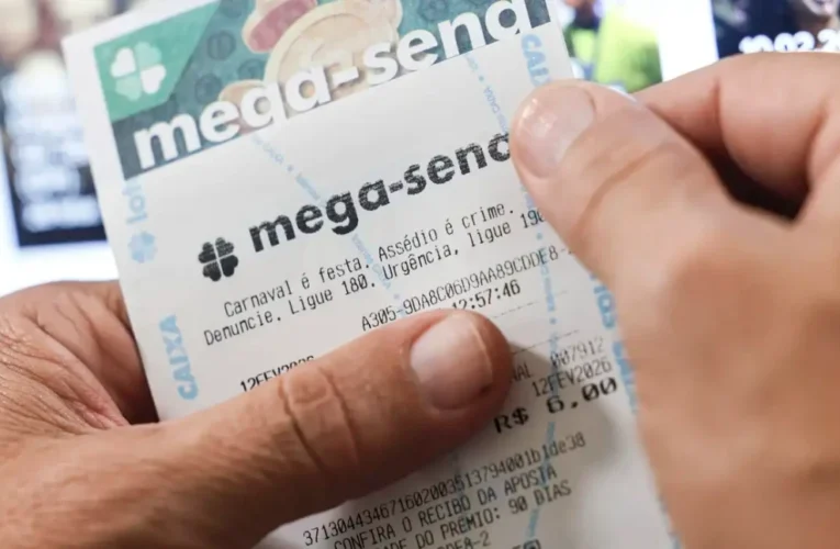 Cartão de aposta da Mega-Sena da Caixa Econômica Federal ao lado de uma caneta