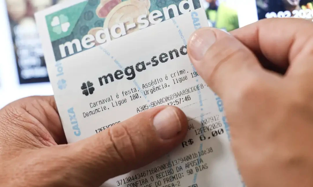 Cartão de aposta da Mega-Sena da Caixa Econômica Federal ao lado de uma caneta