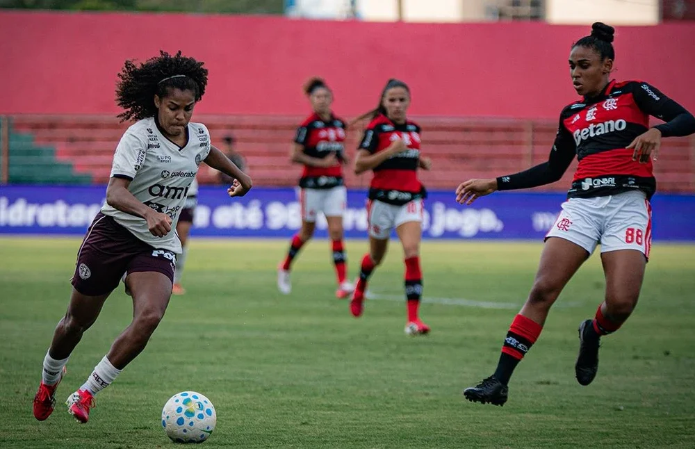 Jogo de futebol feminino amador ilustrando a nova lei que estabelece limites de atletas não profissionais nas competições