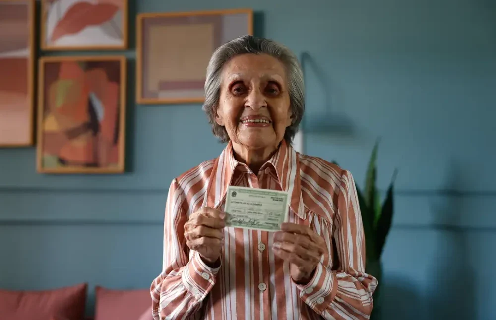 Psicóloga Maria Lidia Gomes de Mattos sendo ajudada por eleitores enquanto vota na Zona Sul do Rio de Janeiro