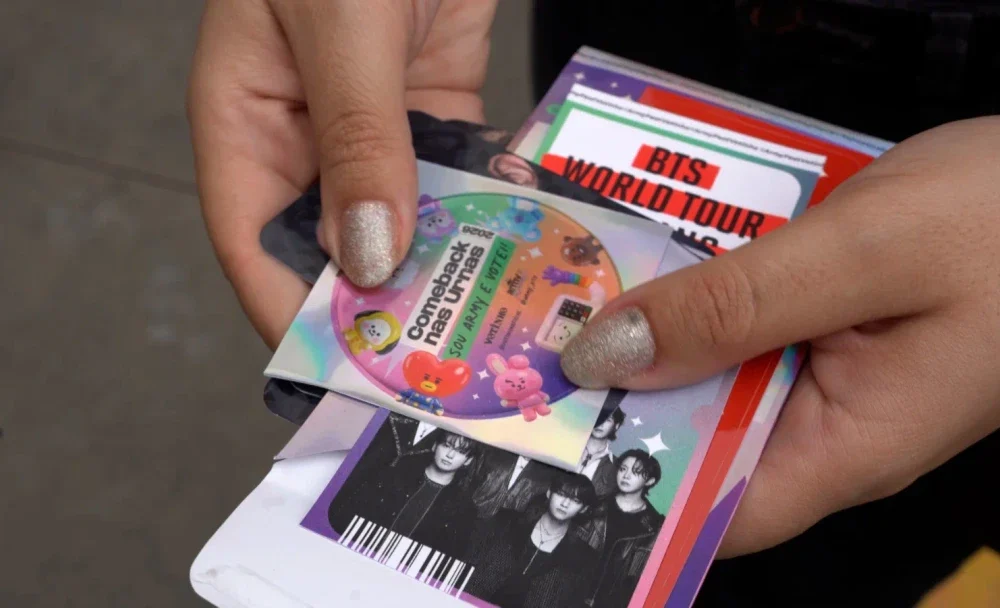 Fãs do BTS exibindo comprovante de votação para receber mystery pack durante concerto em São Paulo