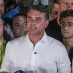 Flávio Bolsonaro segurando carta de agradecimento a Milei e Trump