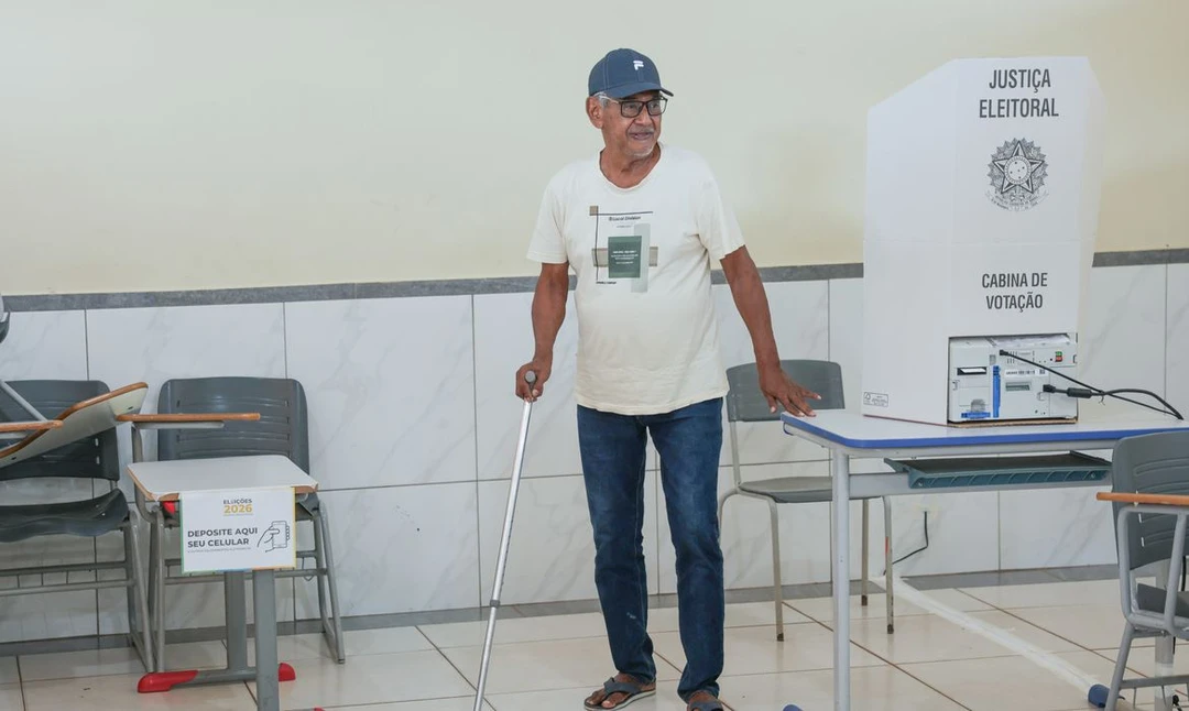 Elenita da Silva, 71 anos, usando bengala enquanto vota na seção eleitoral de Águas Claras