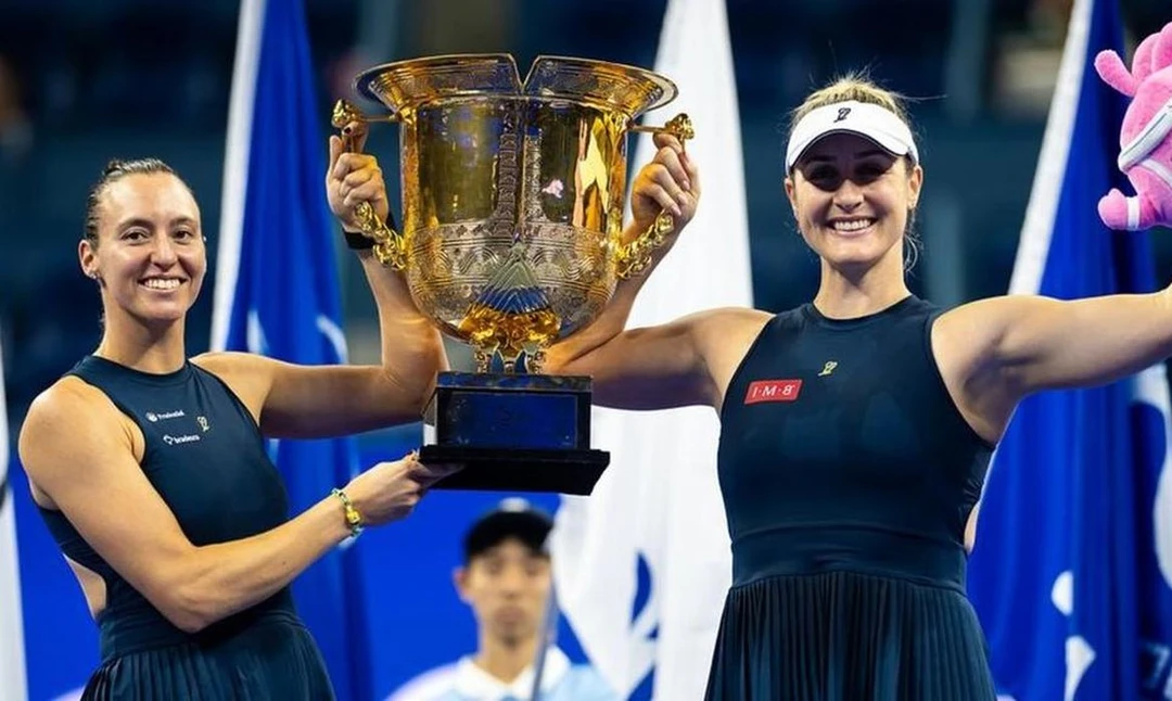 Luisa Stefani e Gabriela Dabrowski erguendo a taça do WTA 1000 de Pequim