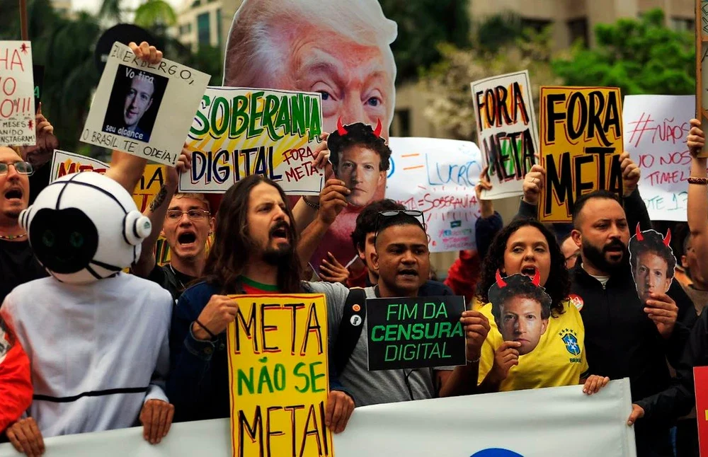 Manifestantes segurando cartazes com o slogan Meta, não se meta diante da sede da Meta na avenida Faria Lima, zona oeste de São Paulo
