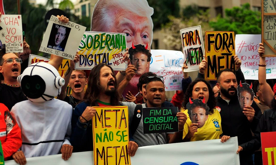 Manifestantes segurando cartazes com o slogan Meta, não se meta diante da sede da Meta na avenida Faria Lima, zona oeste de São Paulo