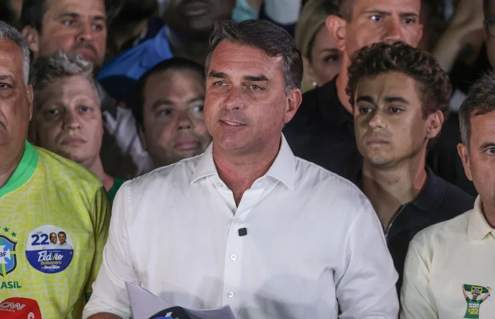 Senador Flávio Bolsonaro, do PL-RJ, ao lado de autoridades da Polícia Federal após o cancelamento de seus passaportes