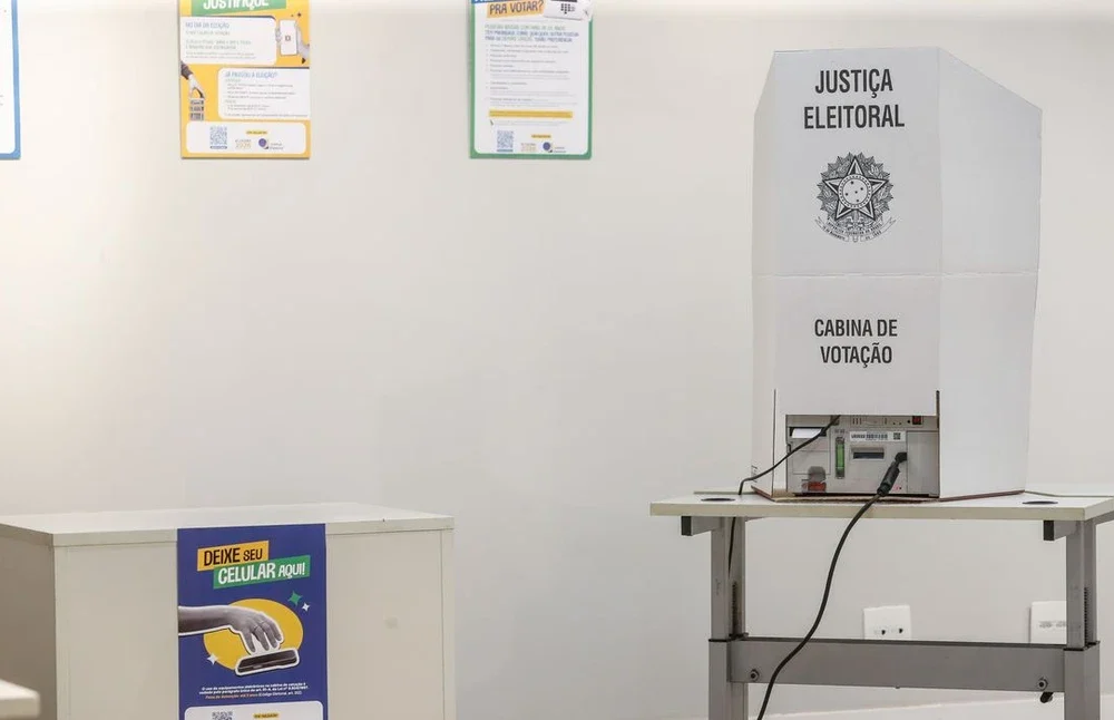 Urna eletrônica com cédulas nas eleições suplementares de prefeitos em cidades brasileiras