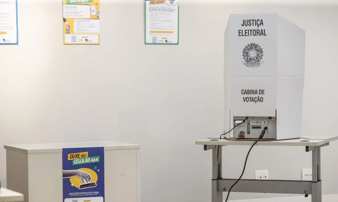 Urna eletrônica com cédulas nas eleições suplementares de prefeitos em cidades brasileiras