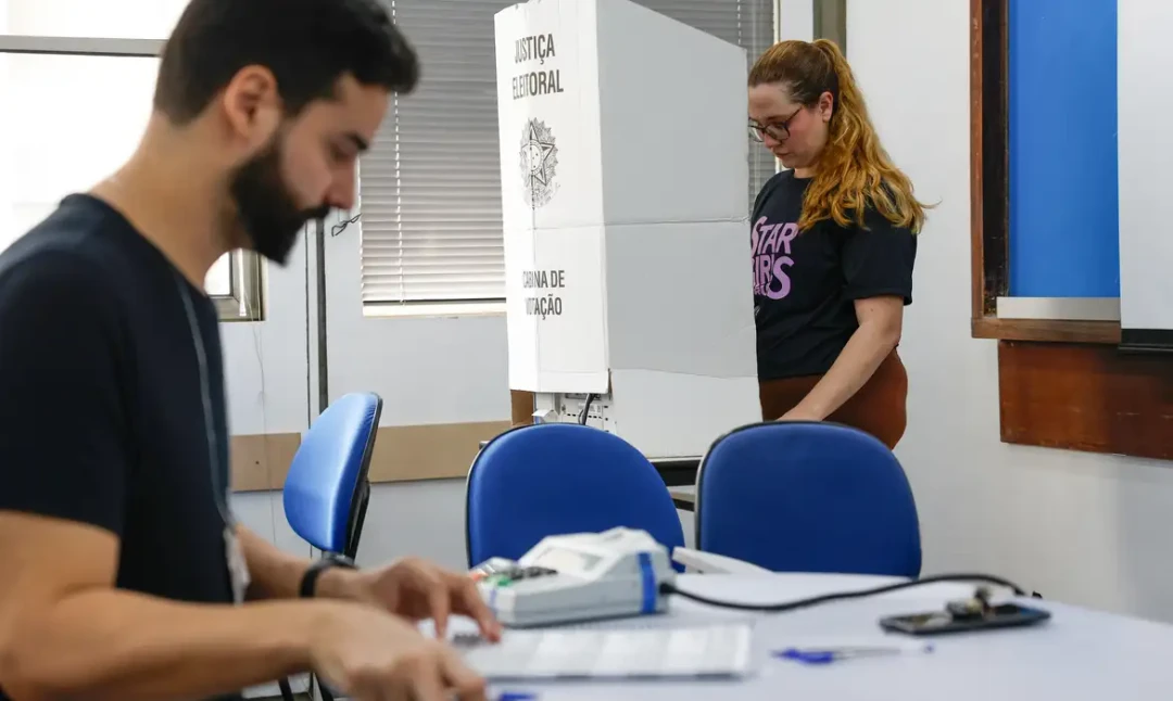 Placa informativa do novo local de votação da Rede de Ensino EEEPV na Rua Irapuá, 243, Penha Circular, Rio de Janeiro
